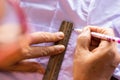 Female hand holding a pencil to draw a line with a white shirt