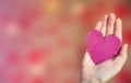 Female hand holding pink glitter heart on romantic blurred bokeh background, copy space or space for text, Valentine`s Royalty Free Stock Photo