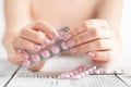 Female Hand holding a pink pill. Royalty Free Stock Photo