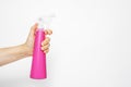 Female hand holding pink sprayer for water on a white background. Pulverizer water for plants. Cleaning the house