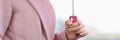 Female hand holding pink umbrella in rain closeup