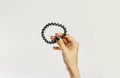 Female hand holding plastic spirally scrunchie. Isolated on gray Royalty Free Stock Photo