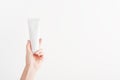 Female hand holding plastic unbranded tube. Flacon for cream, body lotion, toiletry. Container for professional cosmetics product Royalty Free Stock Photo