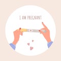 Female hand is holding positive pregnancy or ovulation test. I am pregnant concept with text. Planning baby and