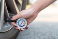 Close up hand holding a pressure gauge measuring a car tyre pressure Royalty Free Stock Photo