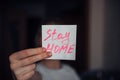 Female hand holding quarantine message: stay home. Self-isolation and protection concept. Sticker with text