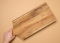 Female hand holding a rectangular wooden cutting board kitchen board Royalty Free Stock Photo