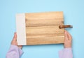 Female hand holding a rectangular wooden cutting board kitchen board Royalty Free Stock Photo
