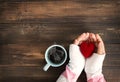 Female hand holding red heart with hot cup of coffee Royalty Free Stock Photo