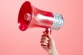 Female Hand Holding Red Megaphone on Pink Background