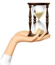 Female hand holding a retro hourglass on the palm isolated on white Royalty Free Stock Photo