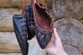 Female hand holding retro shoes leather. Retro style black shoes made of rough material