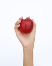 Female hand holding and showing a red apple on white background Royalty Free Stock Photo