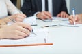 Female hand holding silver pen closeup. Woman writing plan, making notes on business meeting. Teamwork concept. Royalty Free Stock Photo