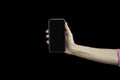 Female hand holding smartphone isolated on black background. Closeup of hand hold mobile phone with clipping path inside Royalty Free Stock Photo