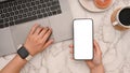 A female hand holding a smartphone and using laptop computer in her stylish feminine workspace Royalty Free Stock Photo