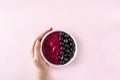 Female hand holding smoothie bowl with acai, banana, blueberries, kiwi fruit and black currants. Healthy super food with fresh Royalty Free Stock Photo
