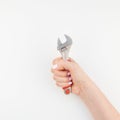 Female hand holding spanner on white background Royalty Free Stock Photo