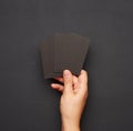 Female hand holding a stack of blank black business cards Royalty Free Stock Photo