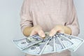 Female hand holding stack 100 dollar bills fanned out on grey background. Money Financial and Payment Concept Royalty Free Stock Photo