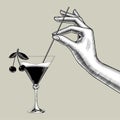 Female hand holding a straw over the cone glass with a ÃÂ¡herry cocktail