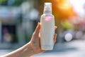 Female hand holding sunblock lotion bottle, uv protection, blurred background with copy space