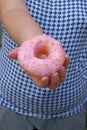 Female hand holding a Sweet donut, dessert