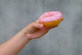 Female hand holding a Sweet donut, dessert