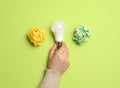 Female hand holding white glass lamp, green energy Royalty Free Stock Photo