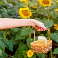 Female hand holding a wicker basket with a jug of sunflower oil Royalty Free Stock Photo