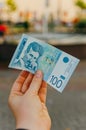 Female hand holds a banknote of 100 one hundred Serbian dinars on a street in the city Royalty Free Stock Photo