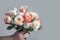 Female hand holds beautiful bouquet of roses. Mothers day, holiday decor, Flower delivery concept. Generative AI
