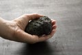 Female hand holds a black stone of lava and magma from the volcano Etna on the island of Sicily, Italy. Stone after the eruption Royalty Free Stock Photo