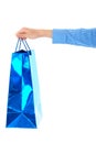 Female hand holds blue gift bag, isolated Royalty Free Stock Photo