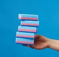 Female hand holds blue stack kitchen sponges for washing dishes