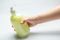 Female hand holds a bottle with liquid yellow antiseptic soap on a white background. Horizontal orientation Royalty Free Stock Photo