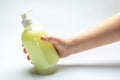 Female hand holds a bottle with liquid yellow soap on a white background. Horizontal orientation Royalty Free Stock Photo