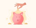 Female hand holds coin and drops it into the piggy bank Royalty Free Stock Photo