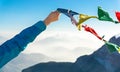 Female hand holds colored flags. Happy success reaching mountain summit. Royalty Free Stock Photo