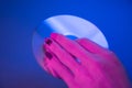 Female hand holds a compact disc on a blue background. Royalty Free Stock Photo