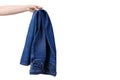 Female hand holds denim pants. Hanging jeans