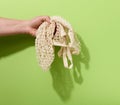 Female hand holds empty green reusable string bag woven from thread on a green background, zero waste Royalty Free Stock Photo