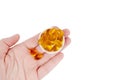 Female hand holds fish oil capsules  on white Royalty Free Stock Photo