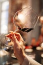 Female hand holds a glass with red wine at a tasting in a wine bar. natural lights Royalty Free Stock Photo