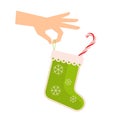 Female hand holds green christmas sock with xmas candy cane. Royalty Free Stock Photo