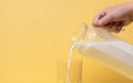 Female hand holds a jug of milk. Milk is poured into a glass. Royalty Free Stock Photo