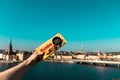 Female hand holds licorice chocolate on a background of a vivid panorama of the city of Stockholm