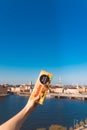 Female hand holds licorice chocolate on a background of a vivid panorama of the city of Stockholm.