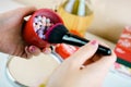 Female hand holds multicoloured highlighting round powder peals in round red box. Makeup product for face treatment Royalty Free Stock Photo