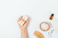 Female hand holds natural soap bar next to sea bath salt Royalty Free Stock Photo